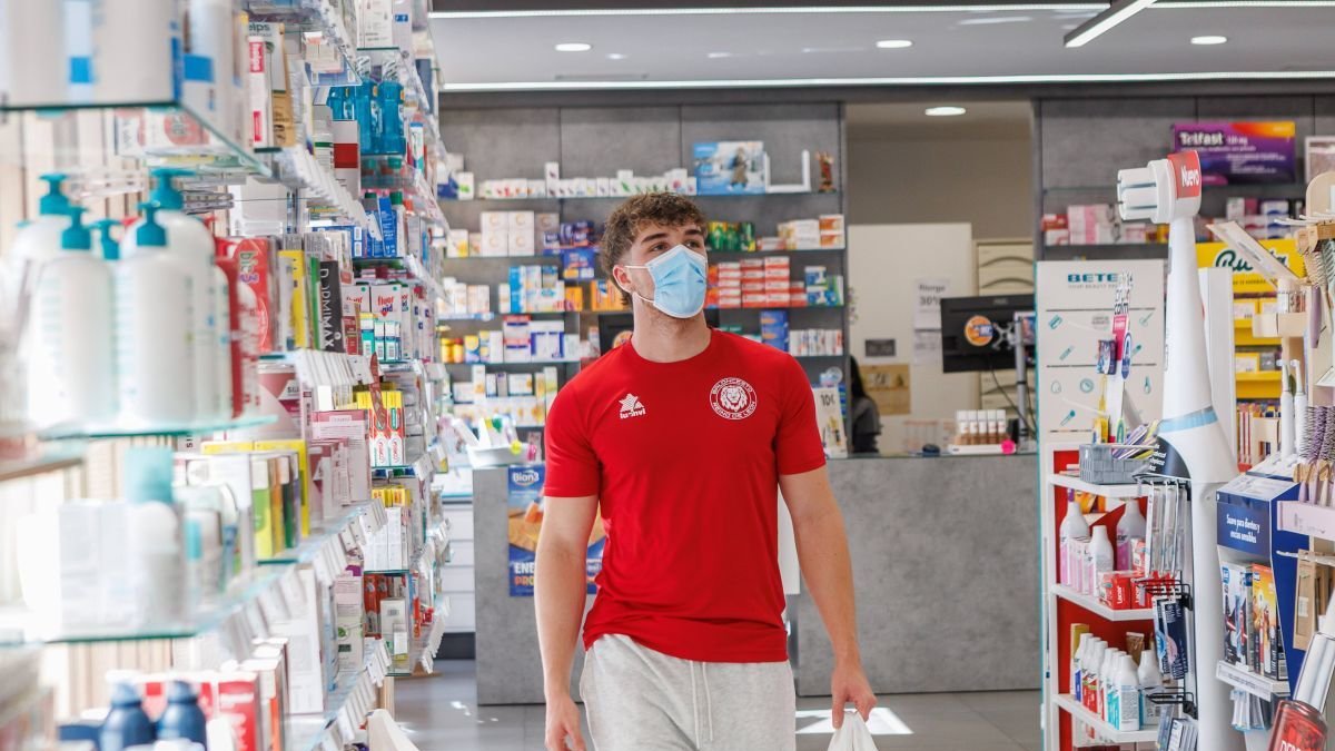 Un joven compra en una farmacia de León protegido por la mascarilla, ayer.