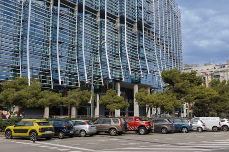 Coches aparcados en semibatería, ante la fachada del edificio Estel