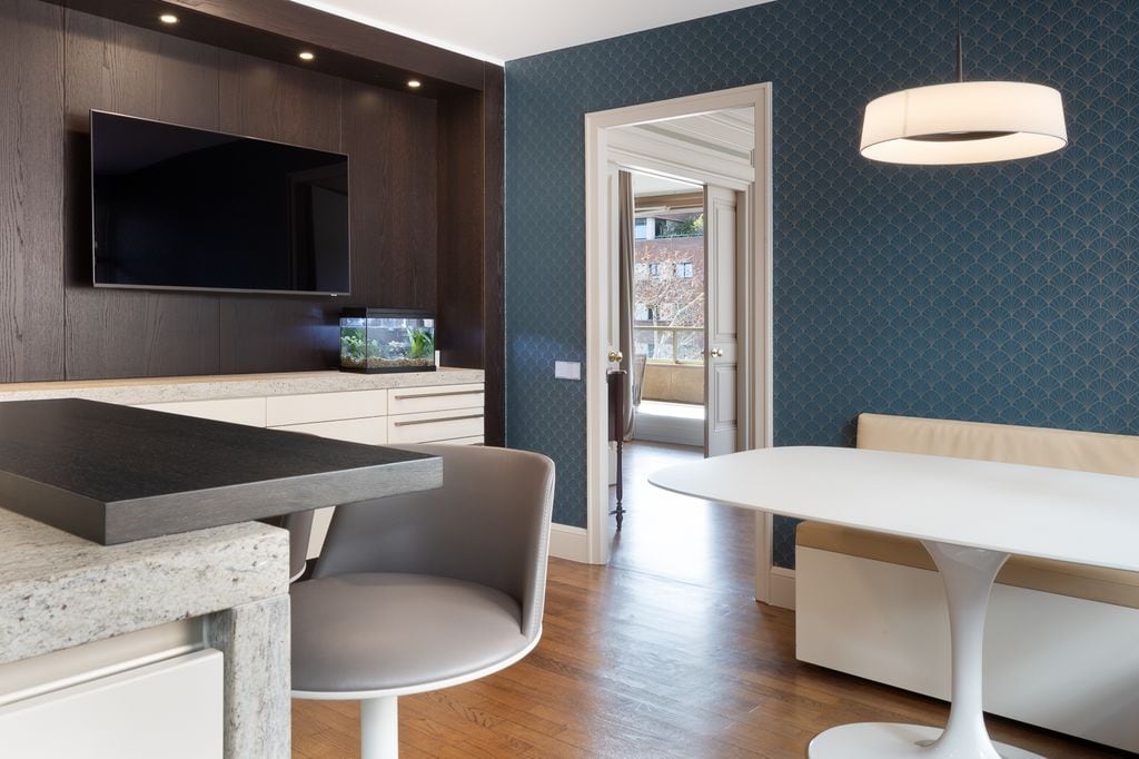 Cocina con zona de comedor y televisor en la pared