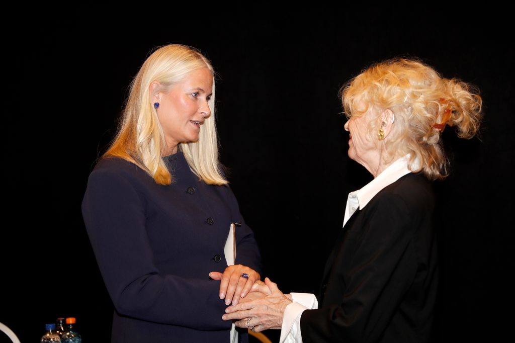 La actriz Liv Ullmann toma las manos de la princesa Mette-Marit