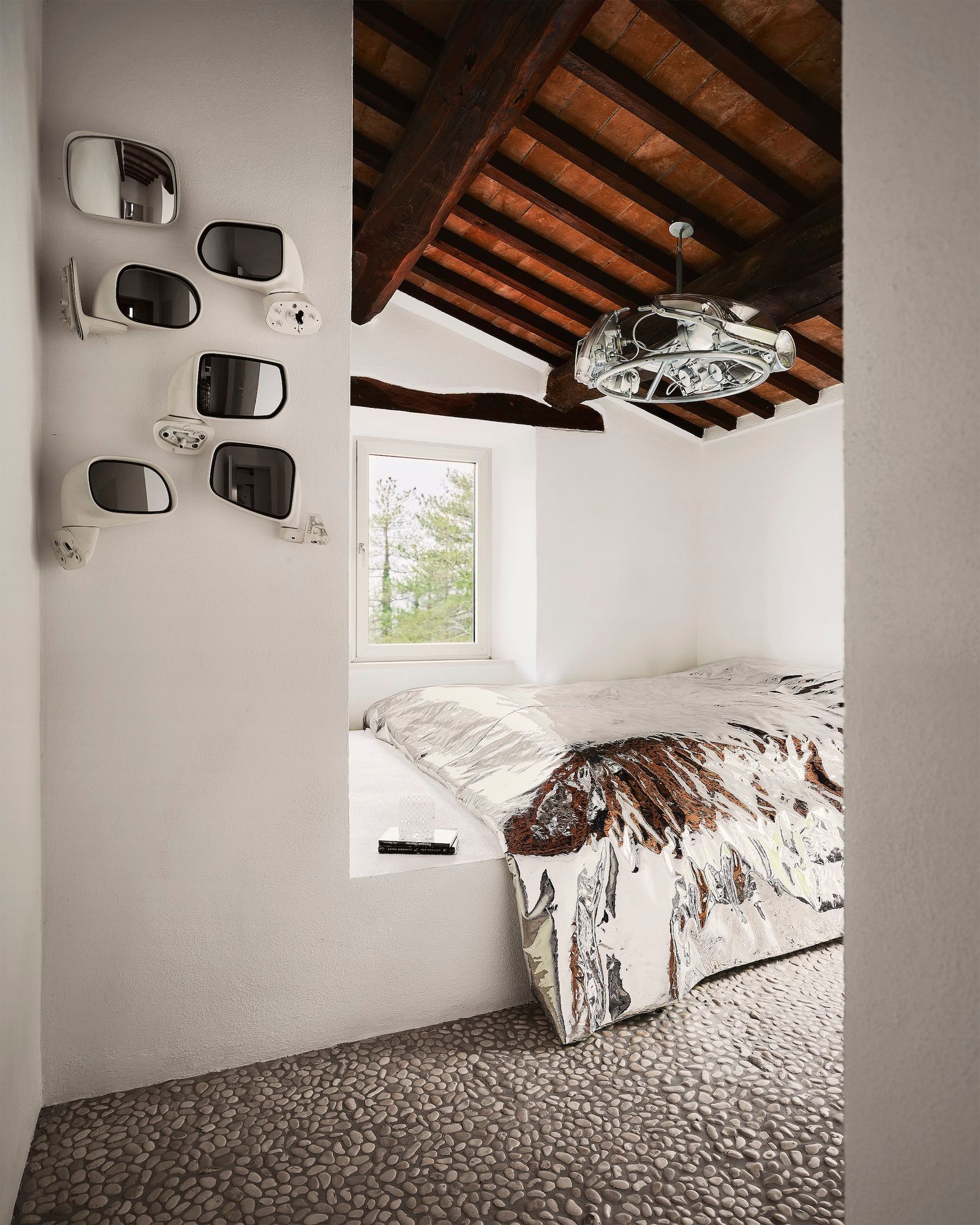 Dormitorio con vigas vistas con accesorios plateados