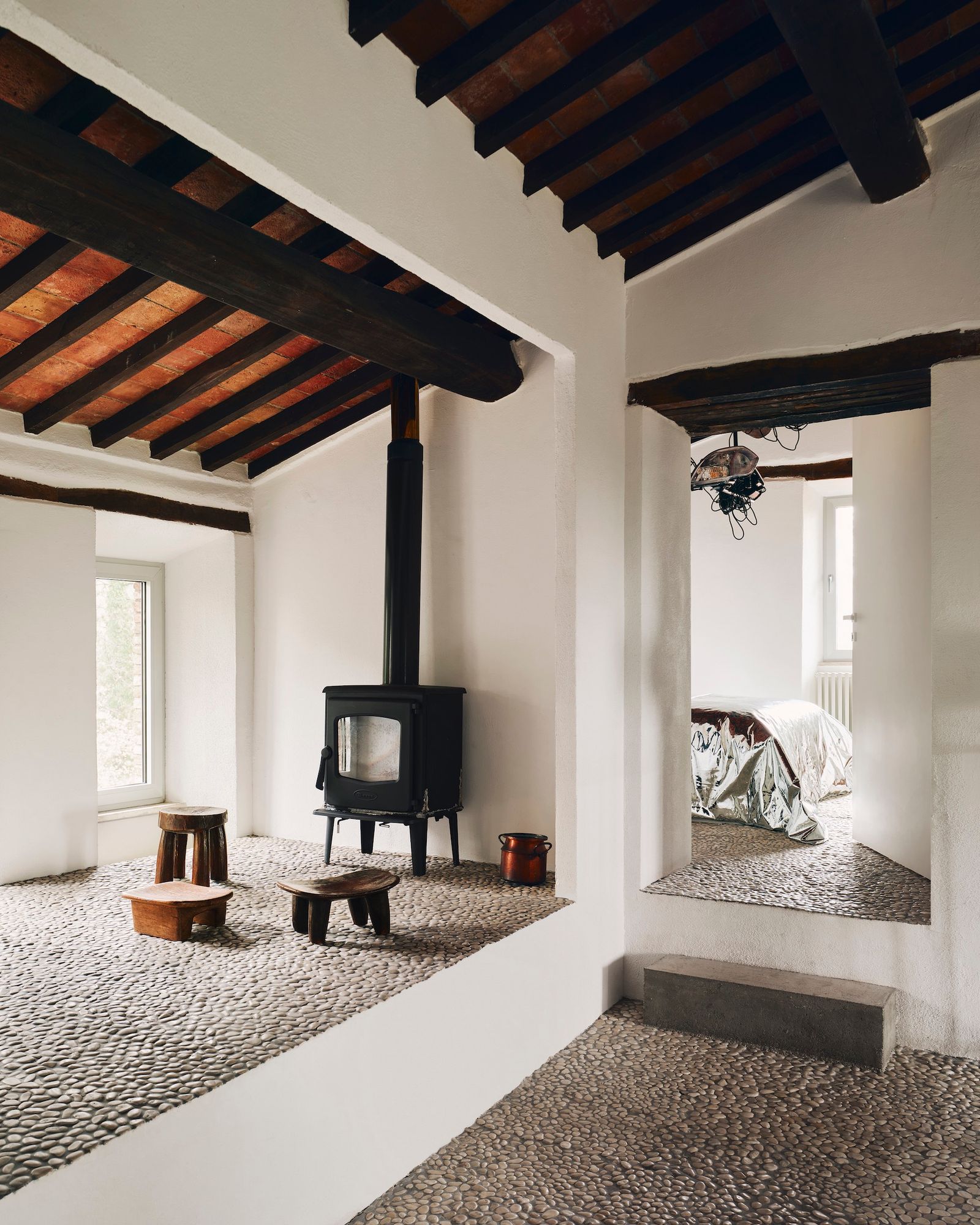 Casa de campo con vigas vistas y estufa de hierro