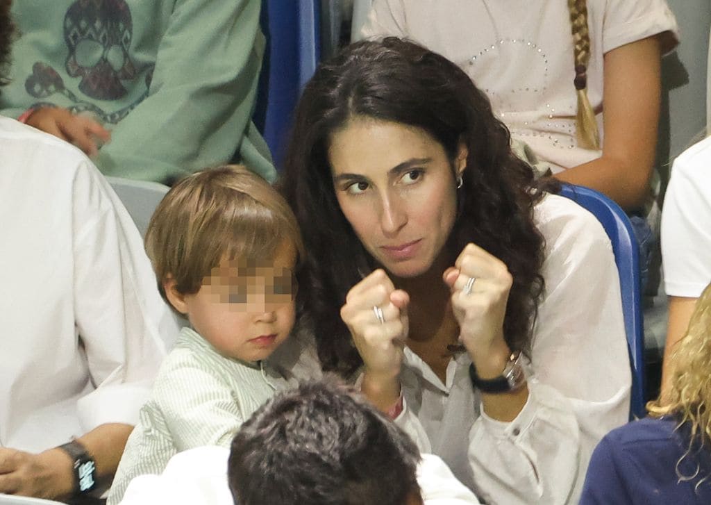Plano medio de Mery Perelló con su hijo viendo a Rafa Nadal durante el partido