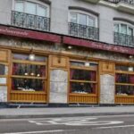 Fachada del emblemático Café Gijón en Madrid con un transeúnte.