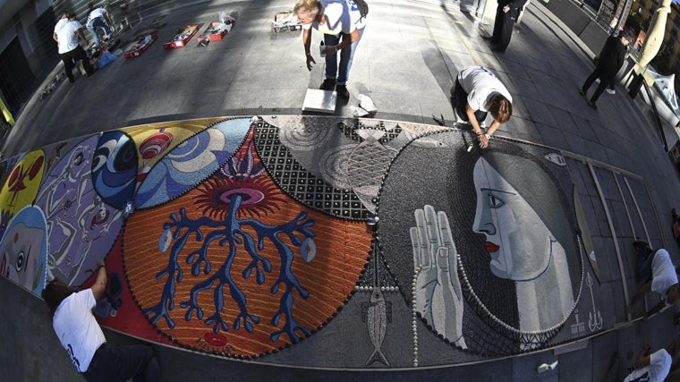 En la entrada principal del Reina Sofía, artesanos de la Asociación Conchas y Flores de Bueu (Pontevedra) se afanaban este martes para crear una alfombra efímera de conchas  de doce metros de largo y dos de ancho