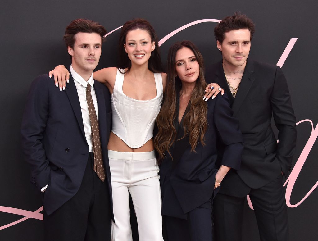 Brooklyn Beckham y Nicola Peltz posan con Victoria con Cruz Bexckham durante un estreno