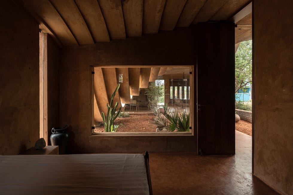 casa de campo de barro con arquitectura escultural y tejado curvado