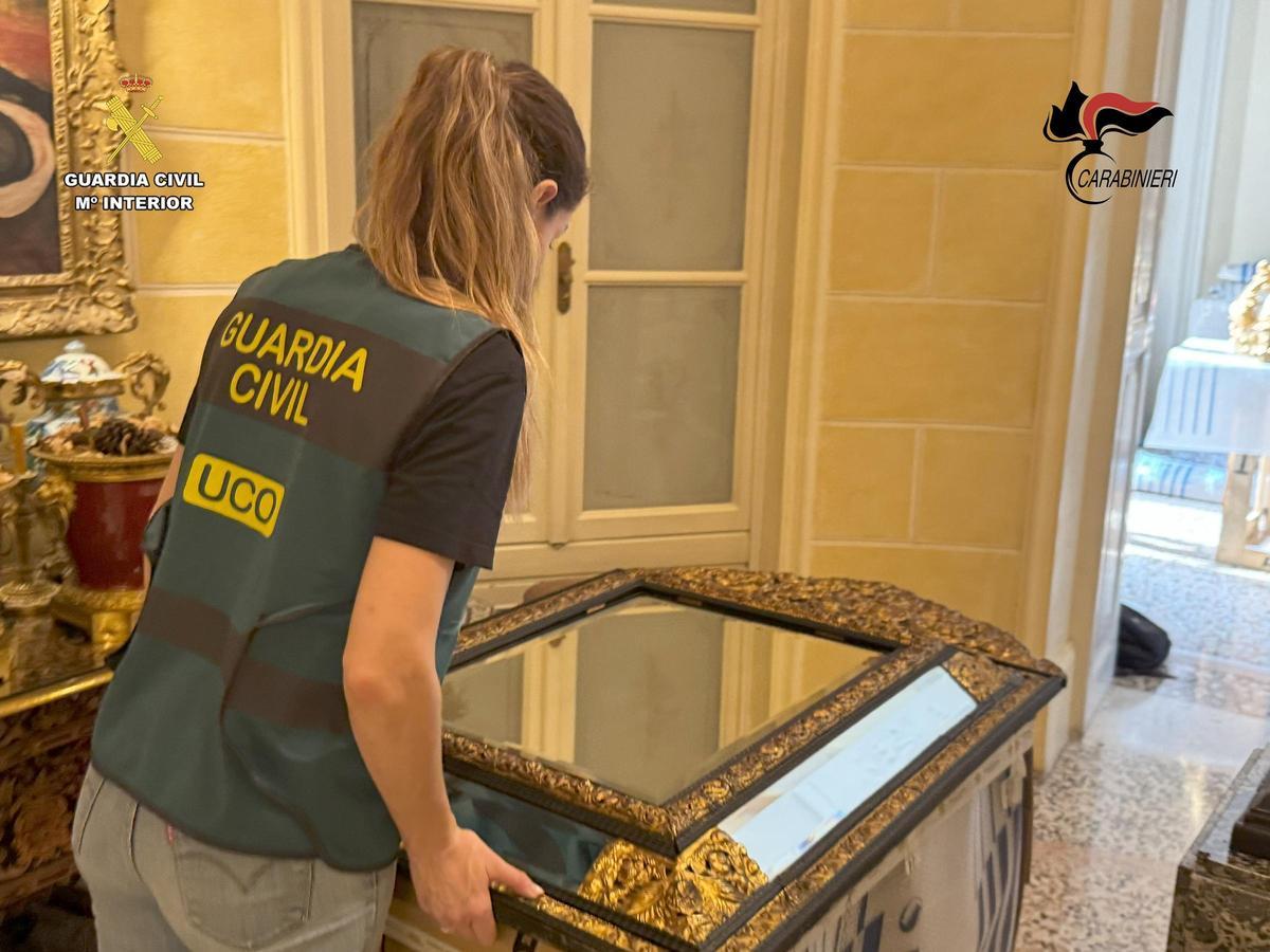 Una agente de la UCO traslada una de las piezas incautadas.