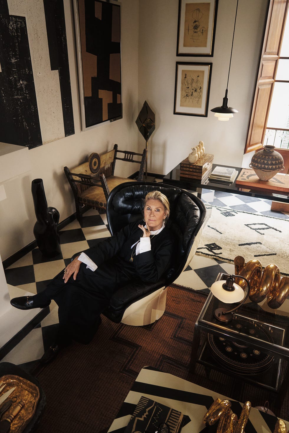 malene birge sentada en una butaca de piel vintage, en un salon con suelo en damero