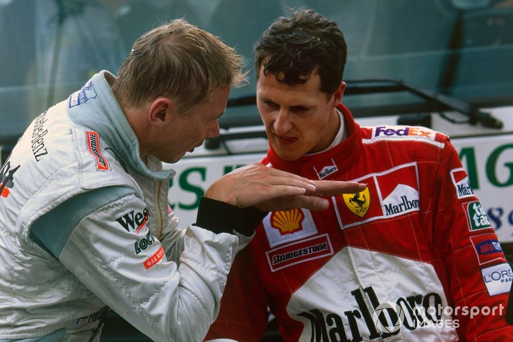Michael Schumacher, Ferrari F1-2000, listens to Mika Hakkinen, McLaren MP4/15 