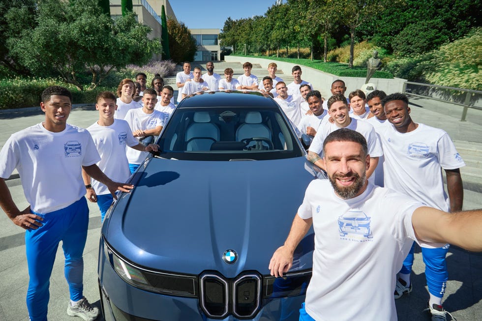 group posing in front of a bmw car