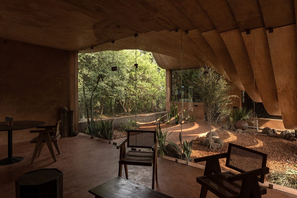 una casa de campo escultural con patio y tejado en curva