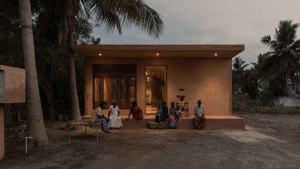 casa escultural y moderna en la india con la familia posando en la entrada
