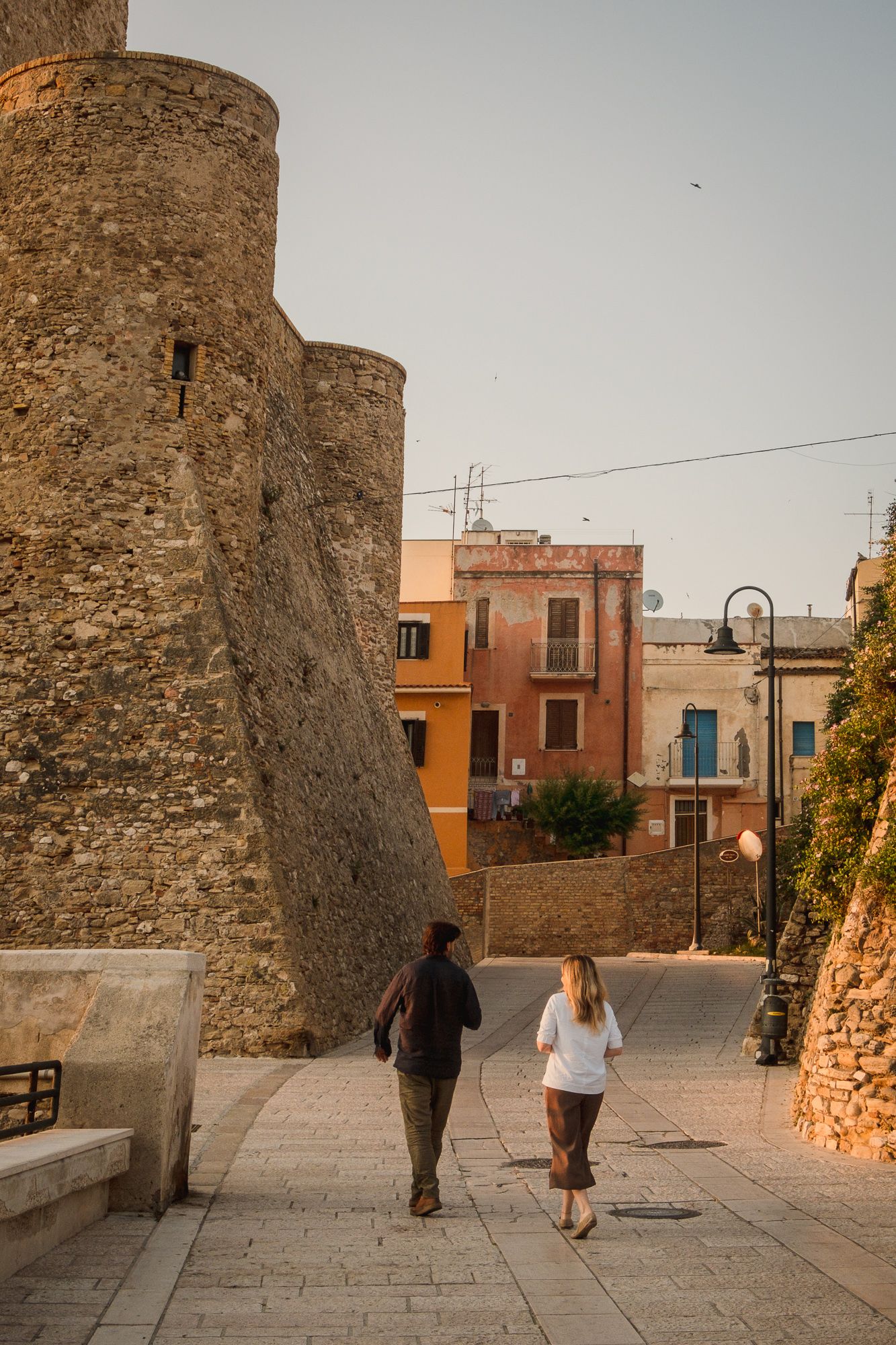 Pareja andando por una calle con castillo centenario
