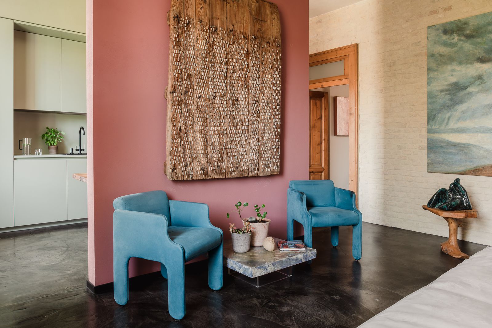 Salón con pared rosa y butacas azules