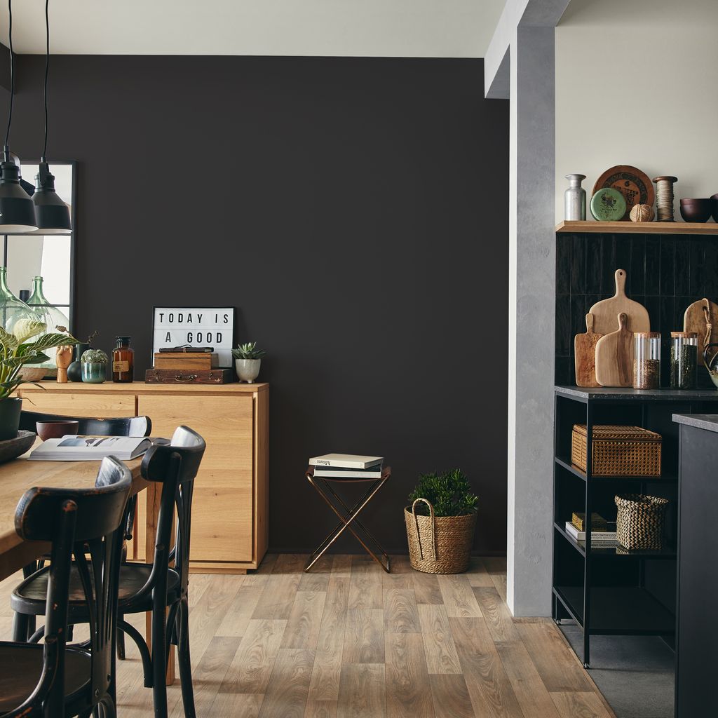 Cocina con pared oscura y muebles de madera