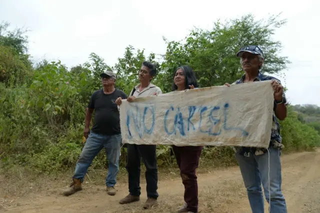 Locales de Santa elena rechazando la construcción de una prisión con un cartel que dice "no cárcel".