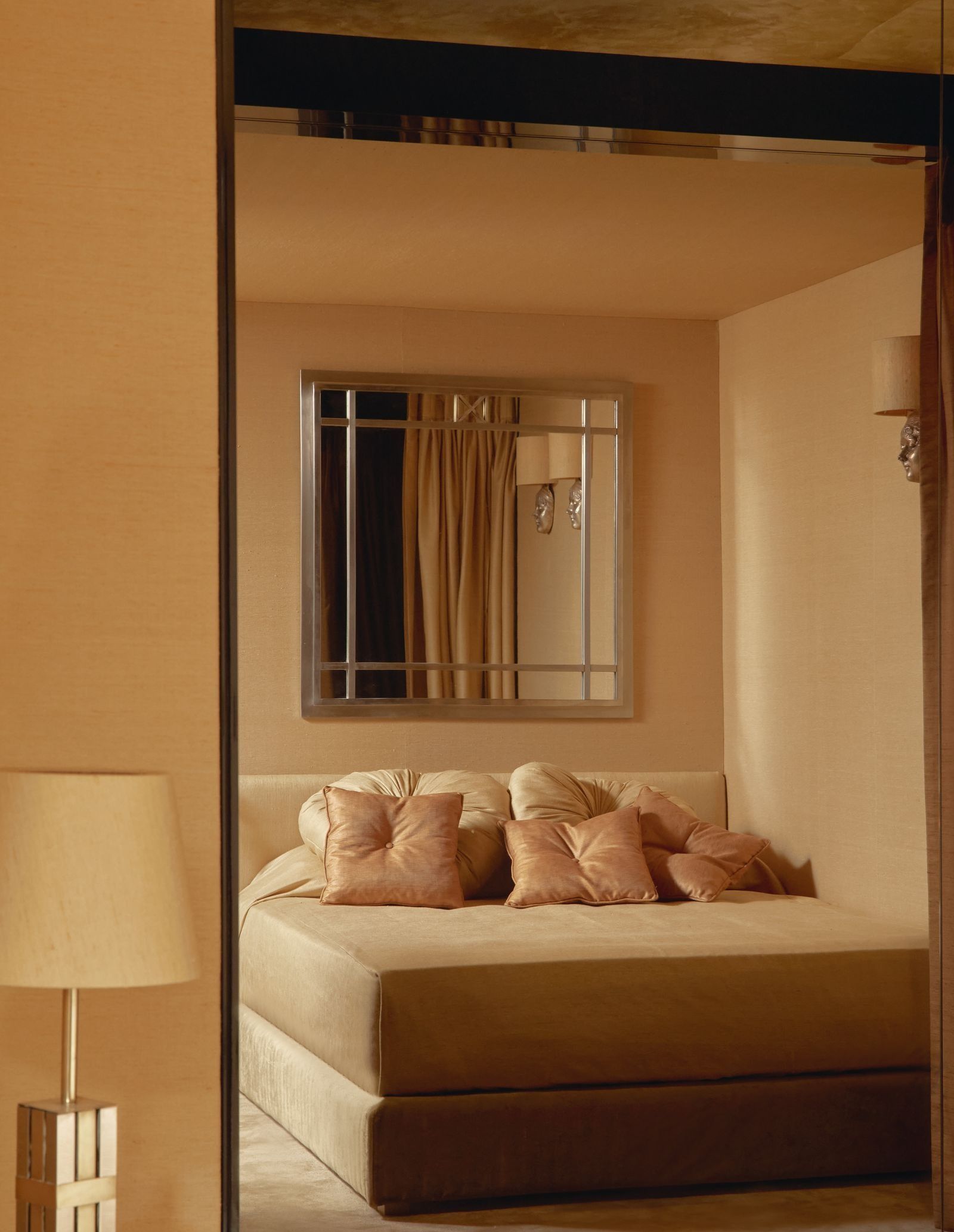 cama de matrimonio con cojines todo en color beige.