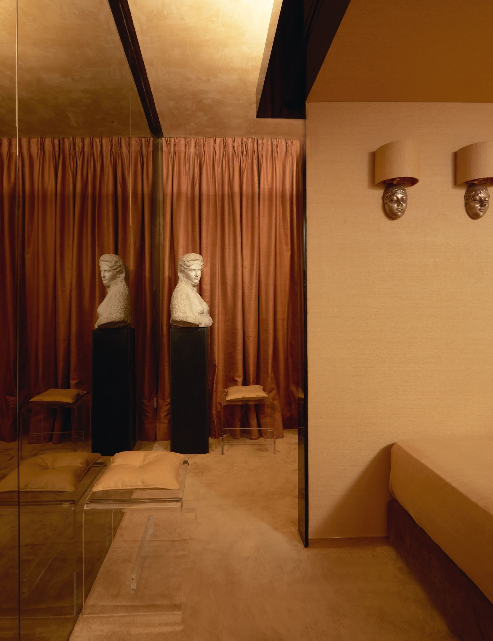 escultura sobre pedestal negro cortinas burdeos hasta el suelo.