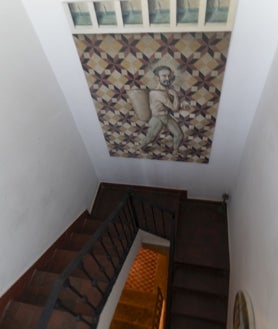 Imagen secundaria 2 - En las imágenes, de arriba abajo, el pintor en su estudio; detalle de las traseras de sus cuadros, en los que Villalta escribe el título y la fecha de inicio; y hueco de la escalera