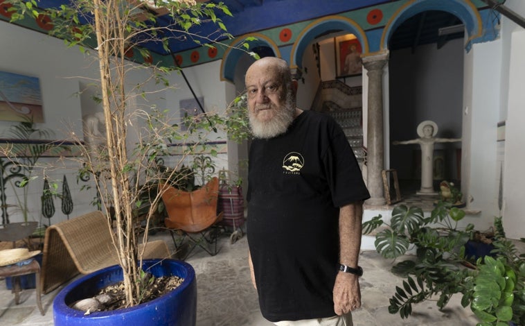 Imagen principal - De arriba abajo, el pintor en el patio de la vivienda; detalle de las puertas de la vivienda, decoradas como los azulejos del suelo; y el artista en su biblioteca, presidida por una réplica de una escultura de Atenea