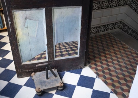 Imagen secundaria 1 - De arriba abajo, el pintor en el patio de la vivienda; detalle de las puertas de la vivienda, decoradas como los azulejos del suelo; y el artista en su biblioteca, presidida por una réplica de una escultura de Atenea