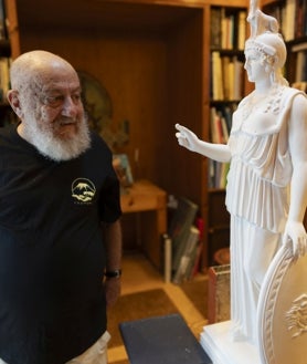 Imagen secundaria 2 - De arriba abajo, el pintor en el patio de la vivienda; detalle de las puertas de la vivienda, decoradas como los azulejos del suelo; y el artista en su biblioteca, presidida por una réplica de una escultura de Atenea