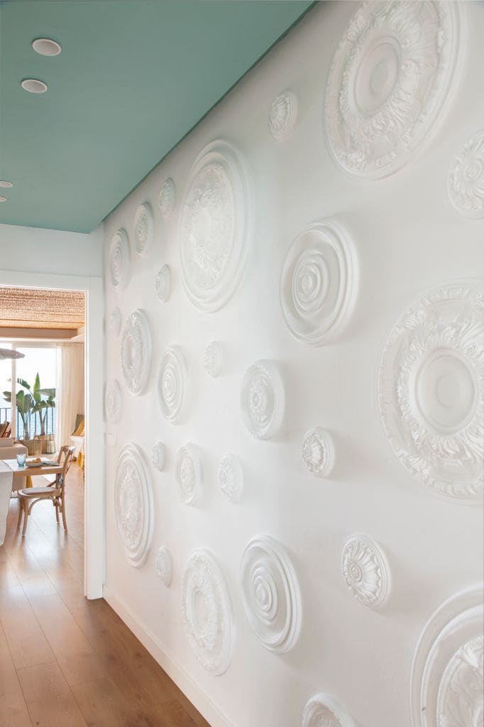 Pasillo con rosetones en la pared, techo verde y suelo de madera