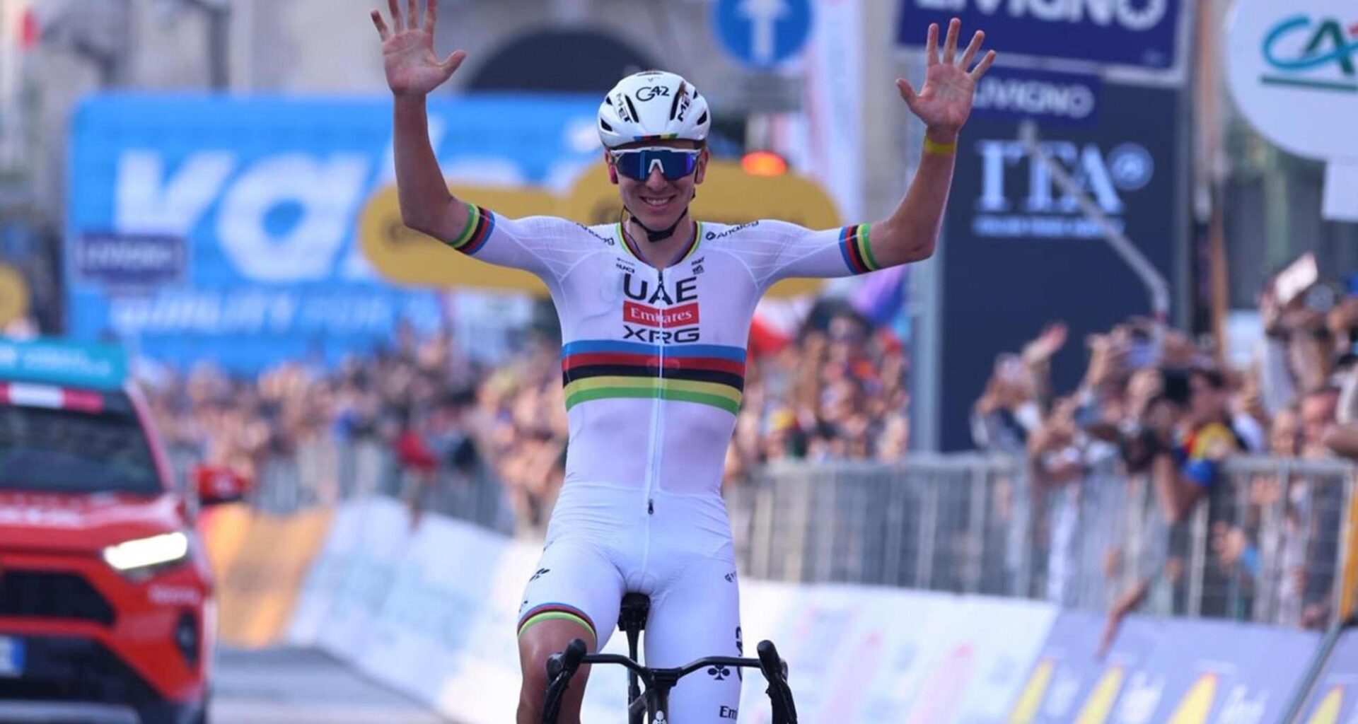 Tadej Pogacar alza los brazos tras cruzar la meta del Giro de Lombardía 2025.