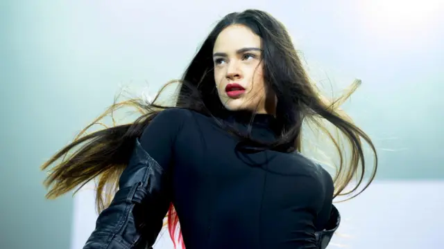 Rosalía con una chaqueta negra, tiene pelo largo y oscuro 