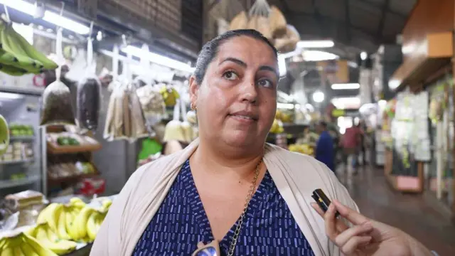 Bárbara Moreno mira hacia un costado mientras es entrevistada en un mercado de Caracas