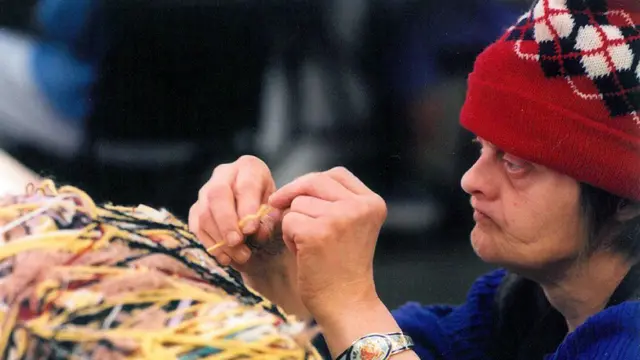 Judith Scott, concentrada, trabajando.