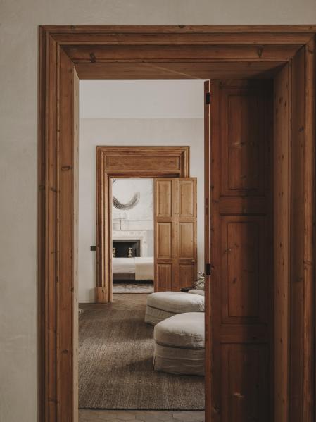 Antesala del dormitorio, con butacas de By Blasco y baldosas de barro