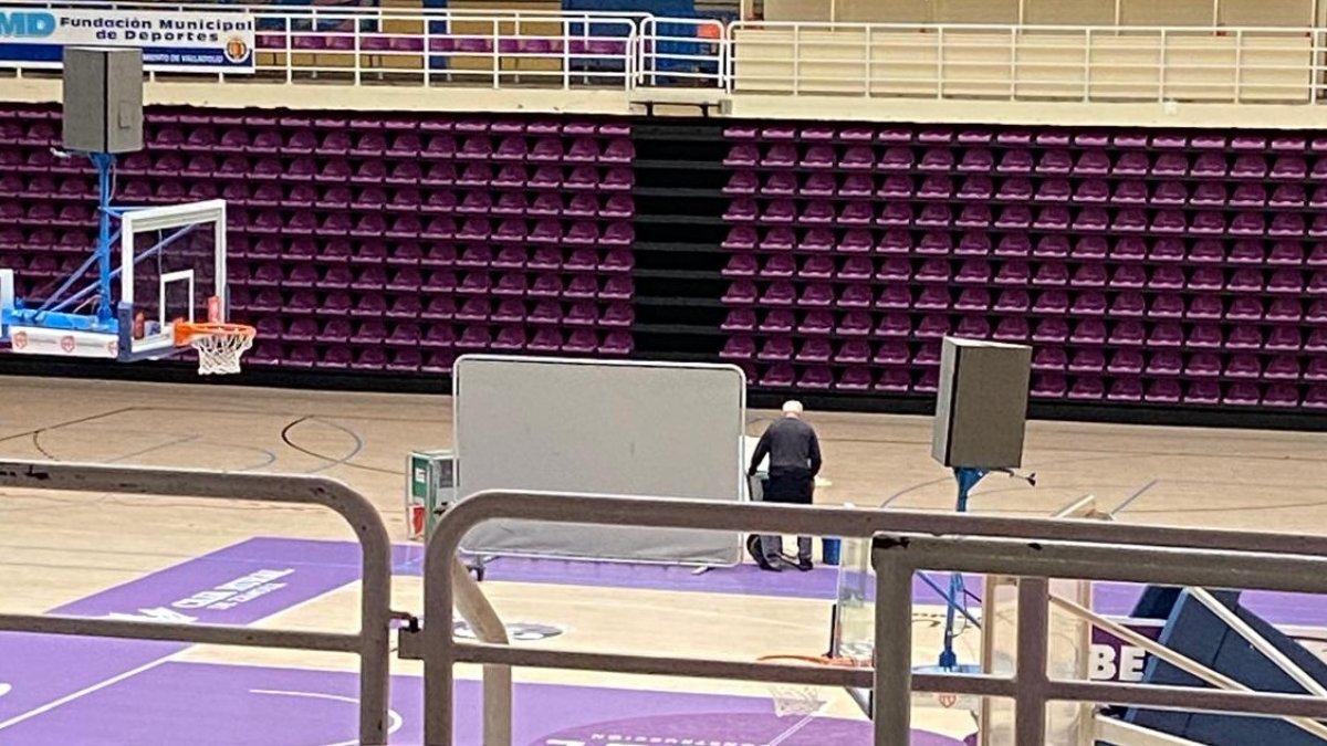 Una mampara tapa los contrapesos puestos en el parquet que se ha abombado en Pisuerga por las goteras.