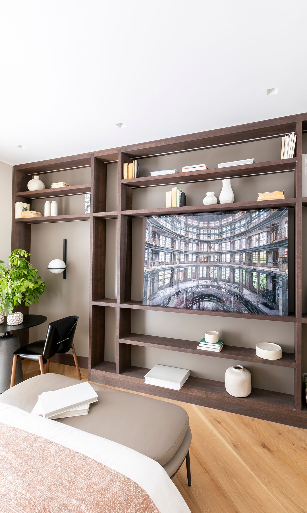 Estantería a medida al pie de la cama en el dormitorio