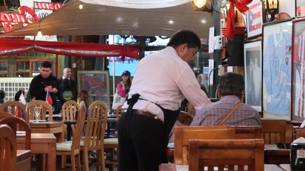 Muchas mesas en el restaurante 'Donde Augusto', dentro del Mercado Central de Santiago, lucen vacías en medio de una caída en las ventas por el alza de la delincuencia en la zona.