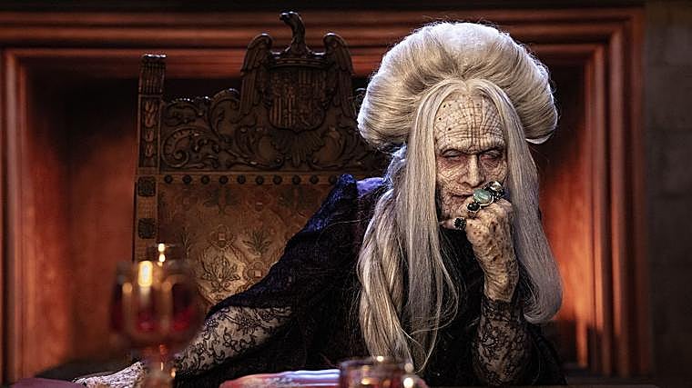 Caleb Landry Jones, en 'Drácula' de Luc Besson, sentado en una silla con el escudo de los Reyes Católicos