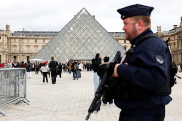 FILE PHOTO: A French CRS riot police officer patrols near the glass Pyramid of the Louvre Museum, after French police arrested suspects in the Louvre heist case, in Paris, France October 27, 2025. REUTERS/Abdul Saboor/File Photo