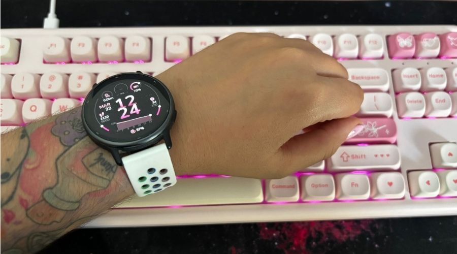 Garmin Vivoactive 5 sobre teclado en uso con esfera rosa