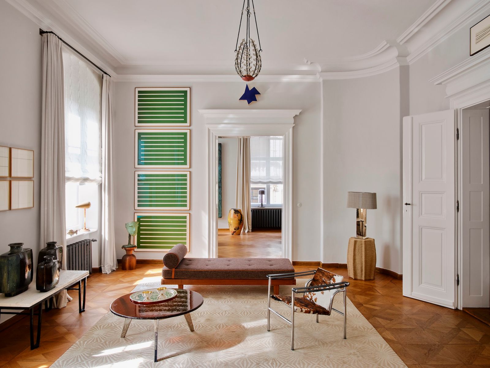Salón blanco con techos altos daybed y obras de Donald Judd