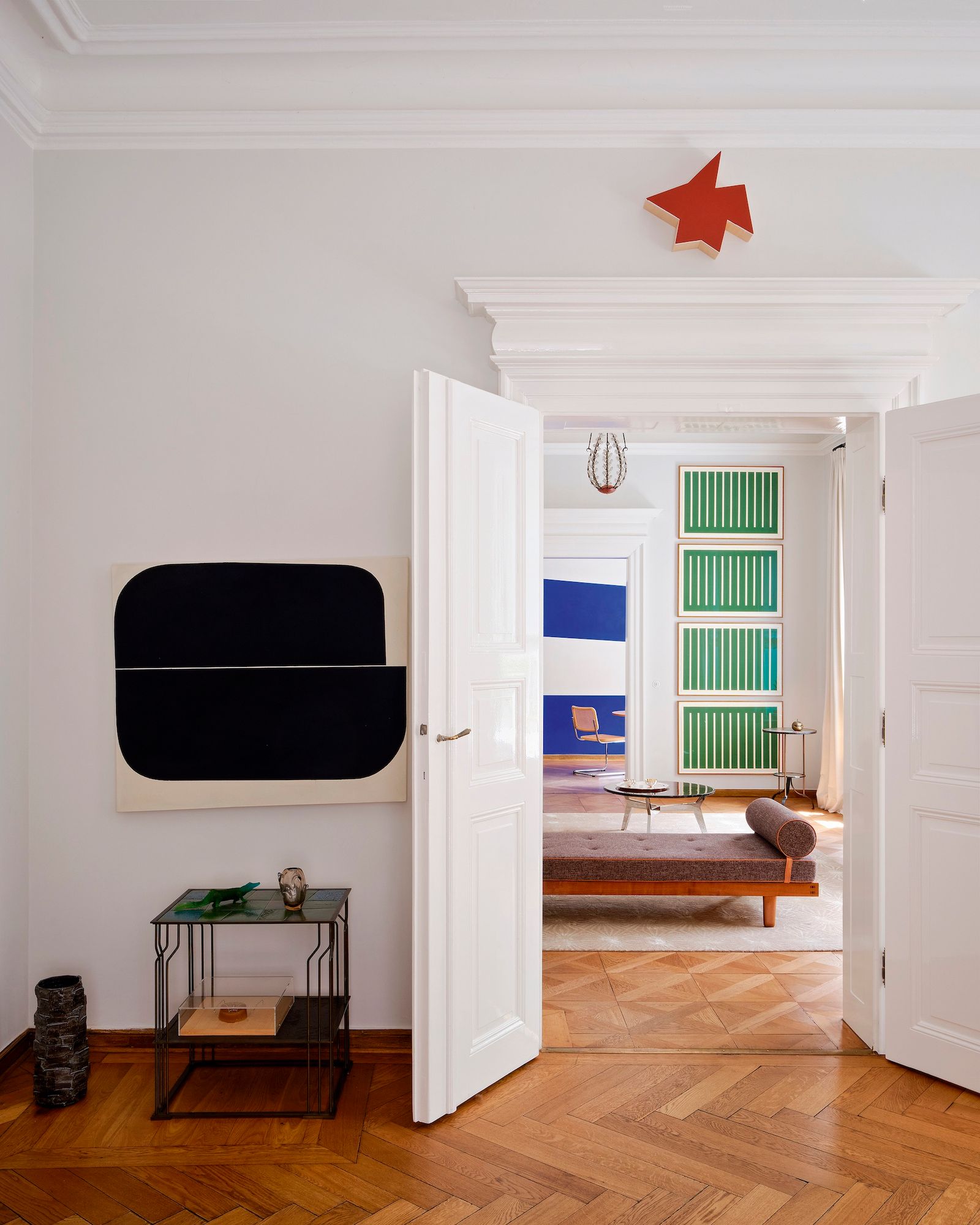 Estancia con obras de arte y puerta a salón con daybed