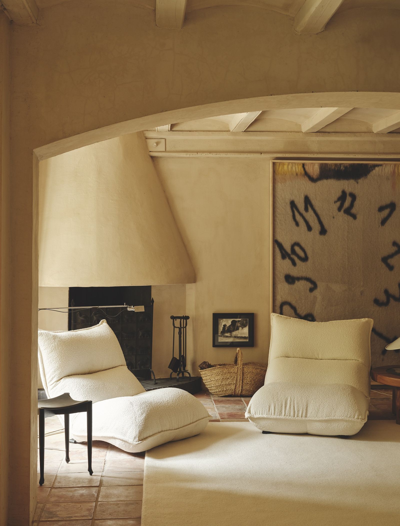 Salón con chimenea y dos butacas neutras