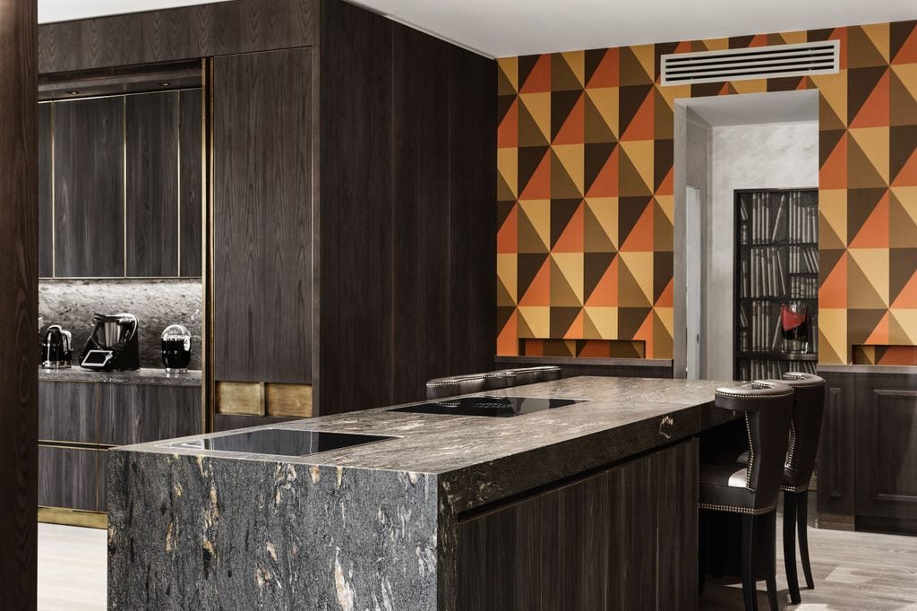 Cocina con muebles oscuros y papel geométrico