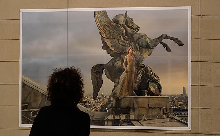 Imagen principal - Arriba, una fotografía de Natalia Vodianova, en lo alto de la ópera de París. Sobre estas líneas, a la izquierda, una vista de la exposición y un retrato de Elon Musk como astronauta