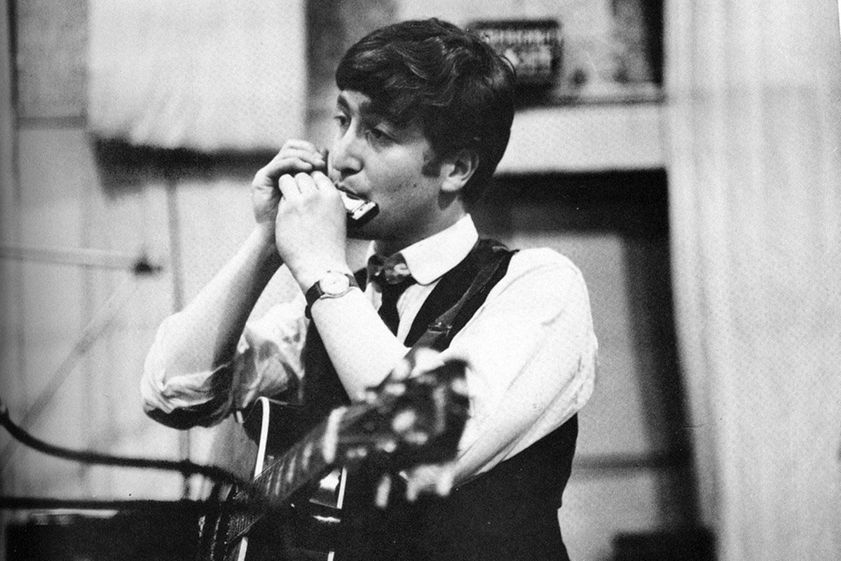John Lennon tocando la armónica en una canción de The Beatles