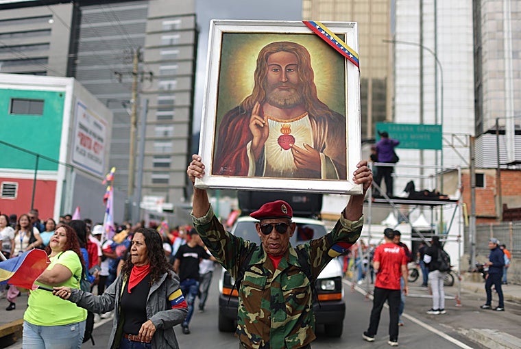 Un simpatizante de Maduro sostiene una imagen del Sagrado Corazón de Jesús este martes en Caracas
