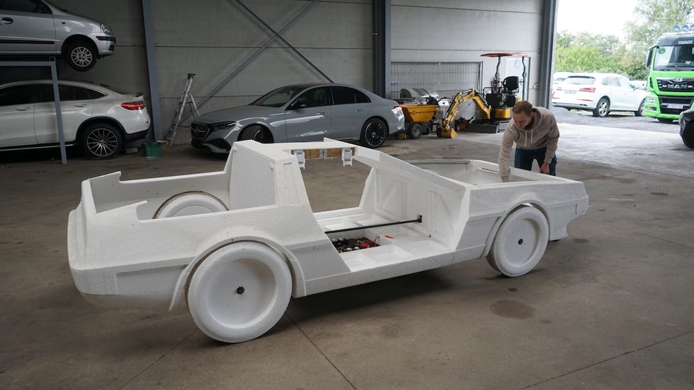 white plastic car chassis under construction in a workshop