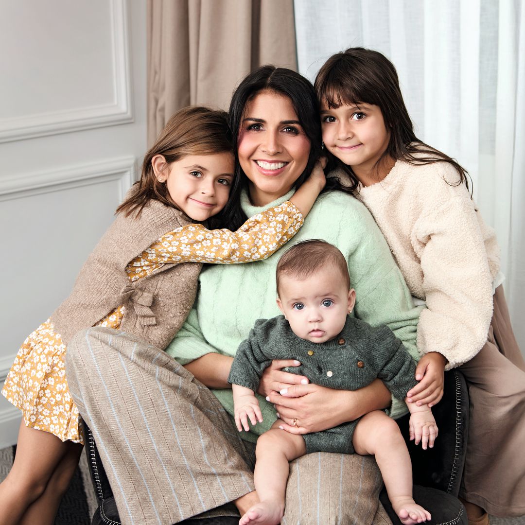 Sara Verdasco con sus tres hijas sentada en un sofá