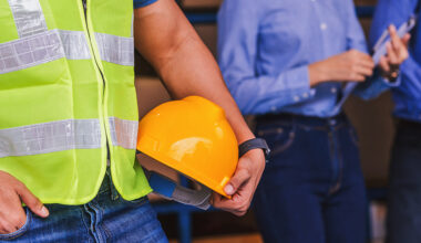 Obrero sujetando un casco amarillo