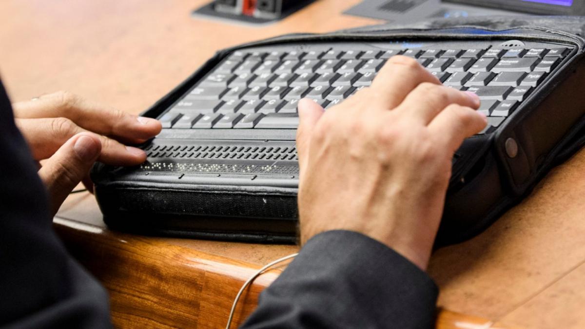 Persona trabajando con un teclado adaptado al lenguaje braille. ONU.